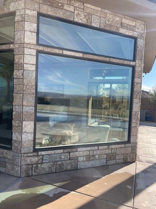 A clean corner window set in stone, reflecting the red cliffs